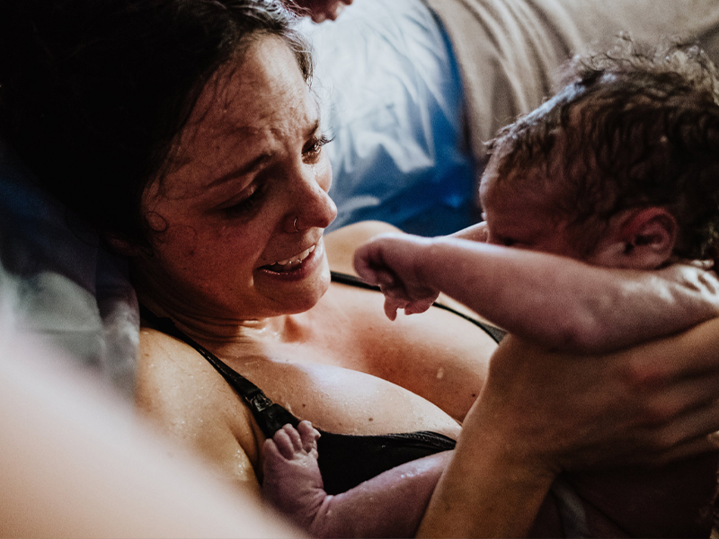 Person holds infant after birth