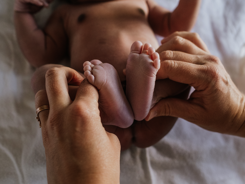 Person holds infant's feet