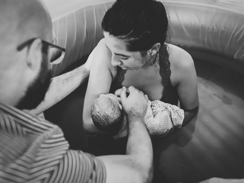 Parents hold infant after water birth
