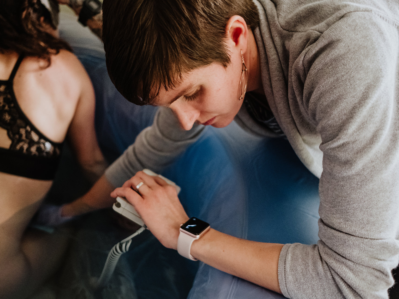 Midwife checks watch during labor