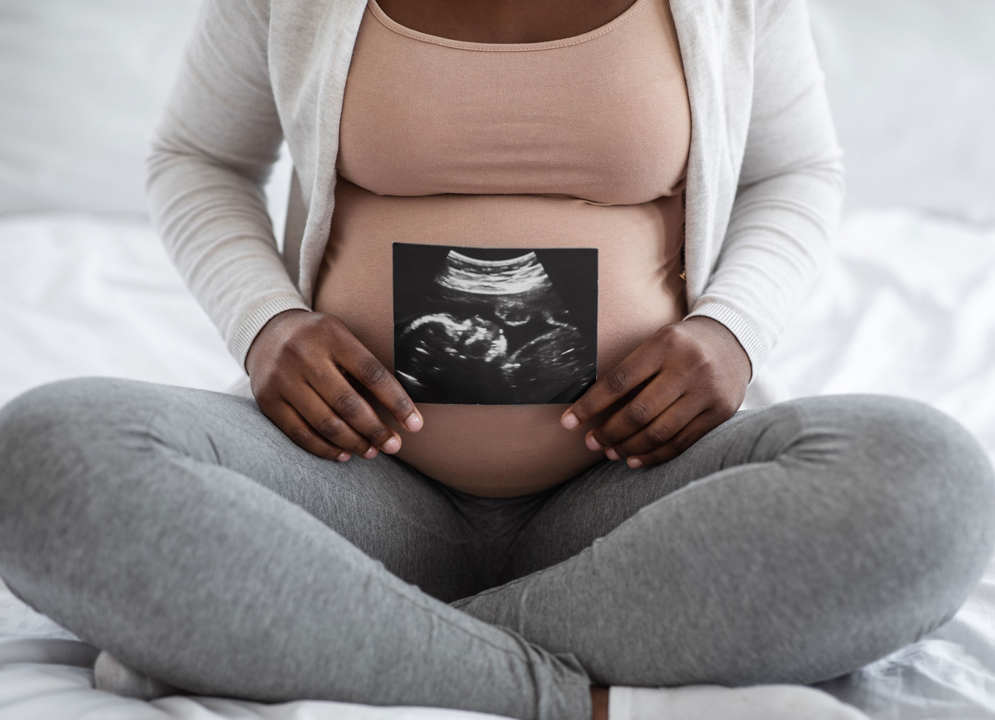 Pregnant person holds sonogram