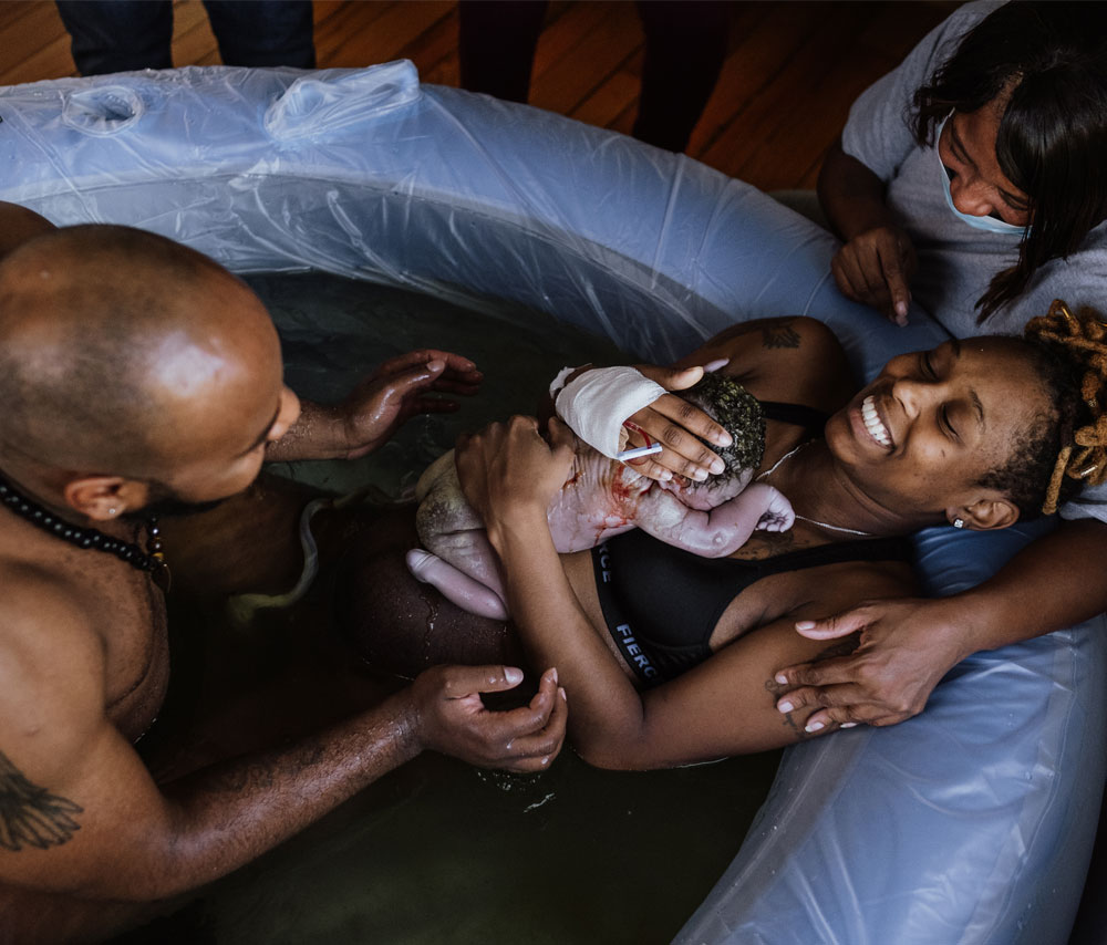 Parents hold infant after water birth